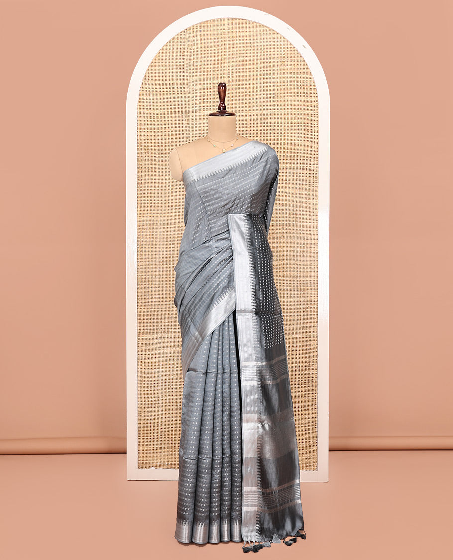 Grey Banana Pith Saree, Subtly Sparkled with Buttas All Over Its Body, Highlighted by Zari Temple Border, Gleaming Pallu Steeped with Stripes, and Paired with a Matching Blouse