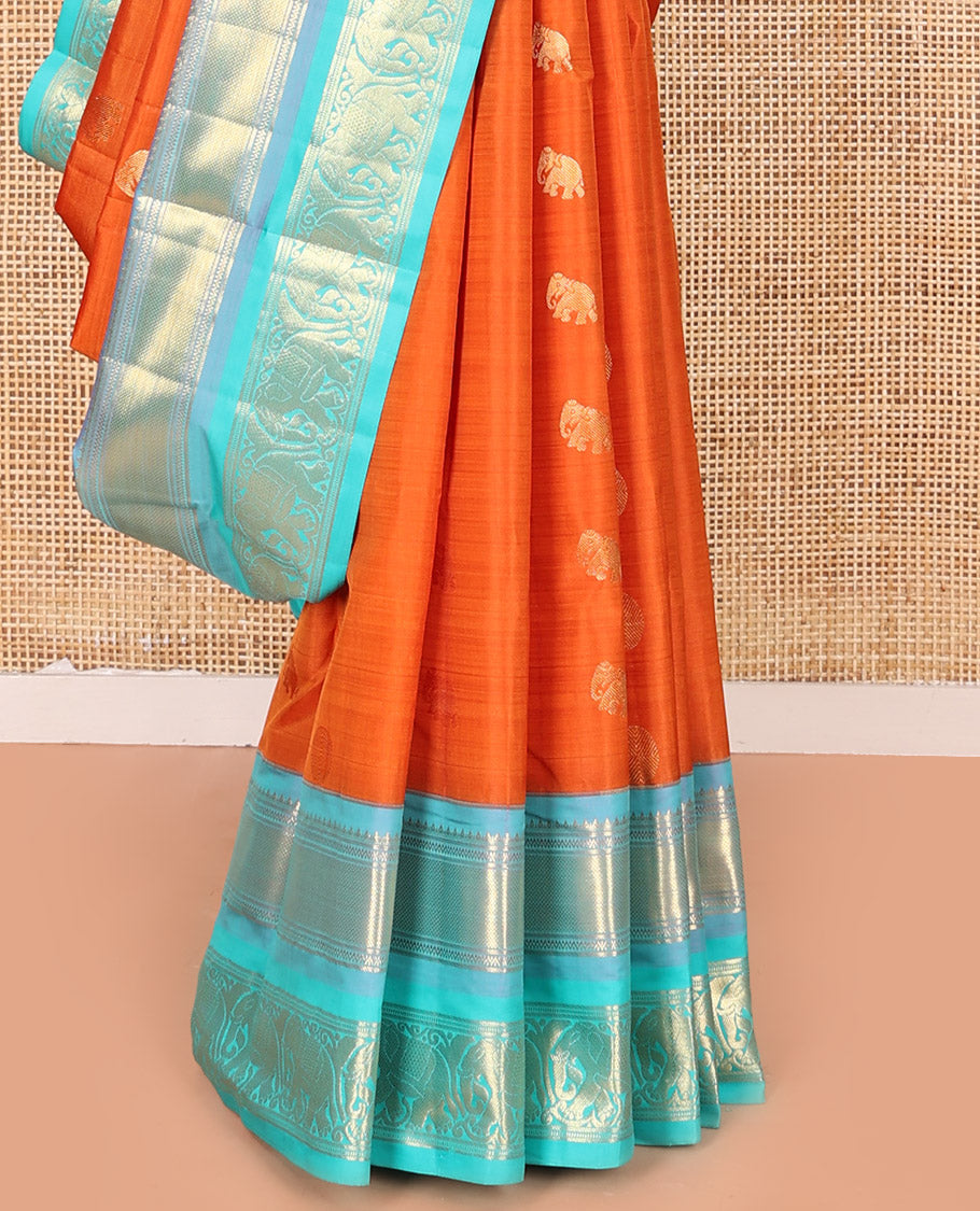 Orange Vasundhara Silk Saree Embellished with Yaanai and Poun Buttas All Over Its Body, Complemented by Zari Border of Neli, Mayil Kann, and Yaanai Designs, a Grand Pallu of Jaal Designs, and Paired with a Contrast Blouse