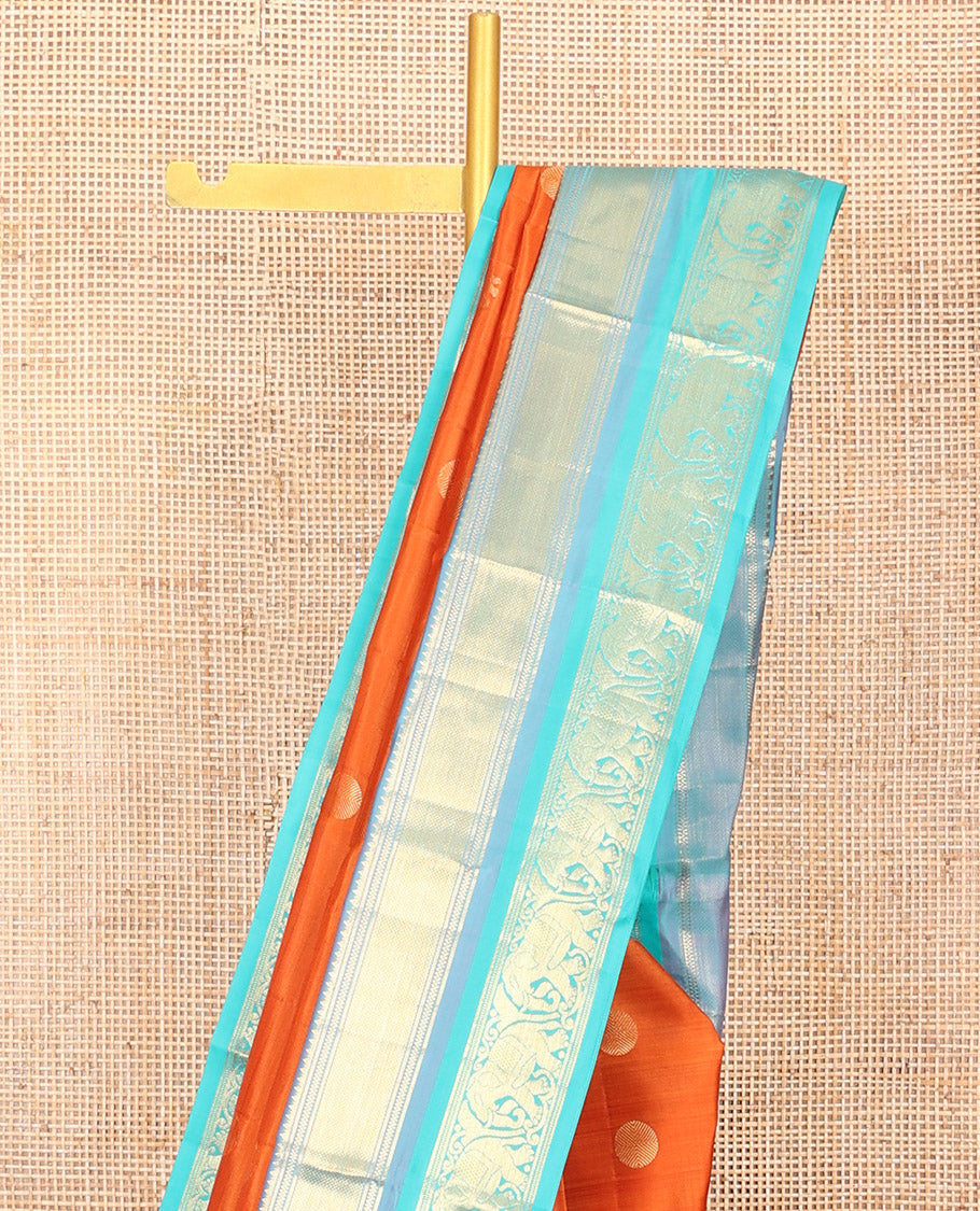 Orange Vasundhara Silk Saree Embellished with Yaanai and Poun Buttas All Over Its Body, Complemented by Zari Border of Neli, Mayil Kann, and Yaanai Designs, a Grand Pallu of Jaal Designs, and Paired with a Contrast Blouse