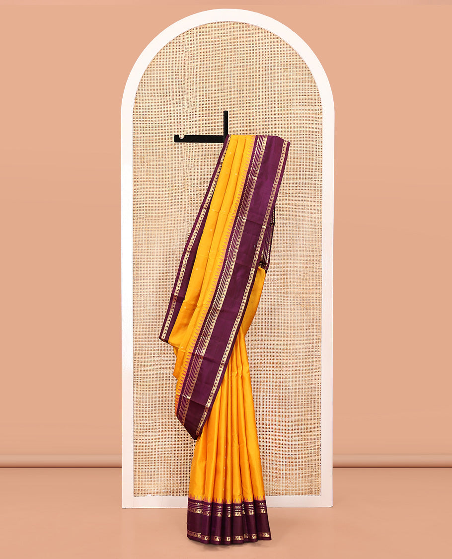 Yellow Vasundhara Silk Saree, Subtly Sparkled with Zari Buttas All Over Its Body, Complemented by a Contrast Rettai Pettu Temple Border of Rekku, Muthu, Manga, and Thazampoo Rekku Designs, Grand Pallu, and Paired with a Contrast Blouse