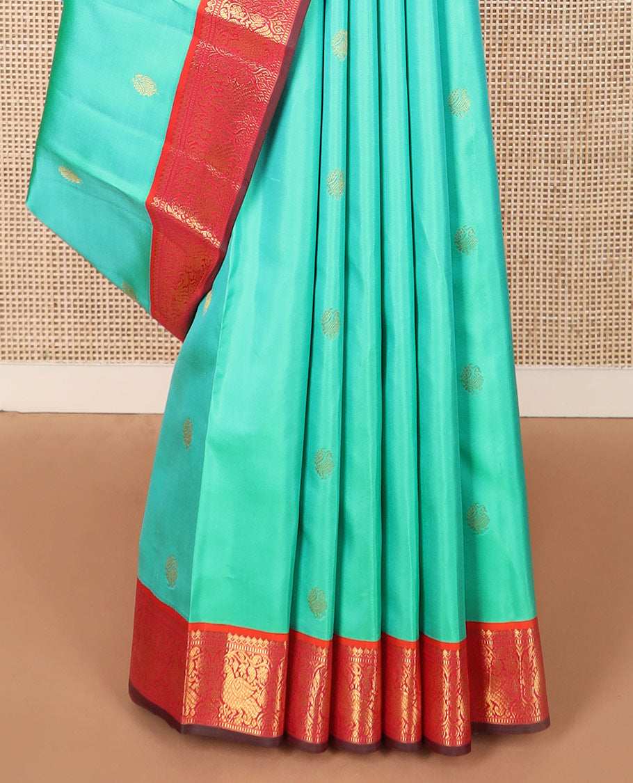 Turquoise mayil buttas silk saree, contrast border of thilakam mokku, muthu, and mayil designs, and jaal pallu