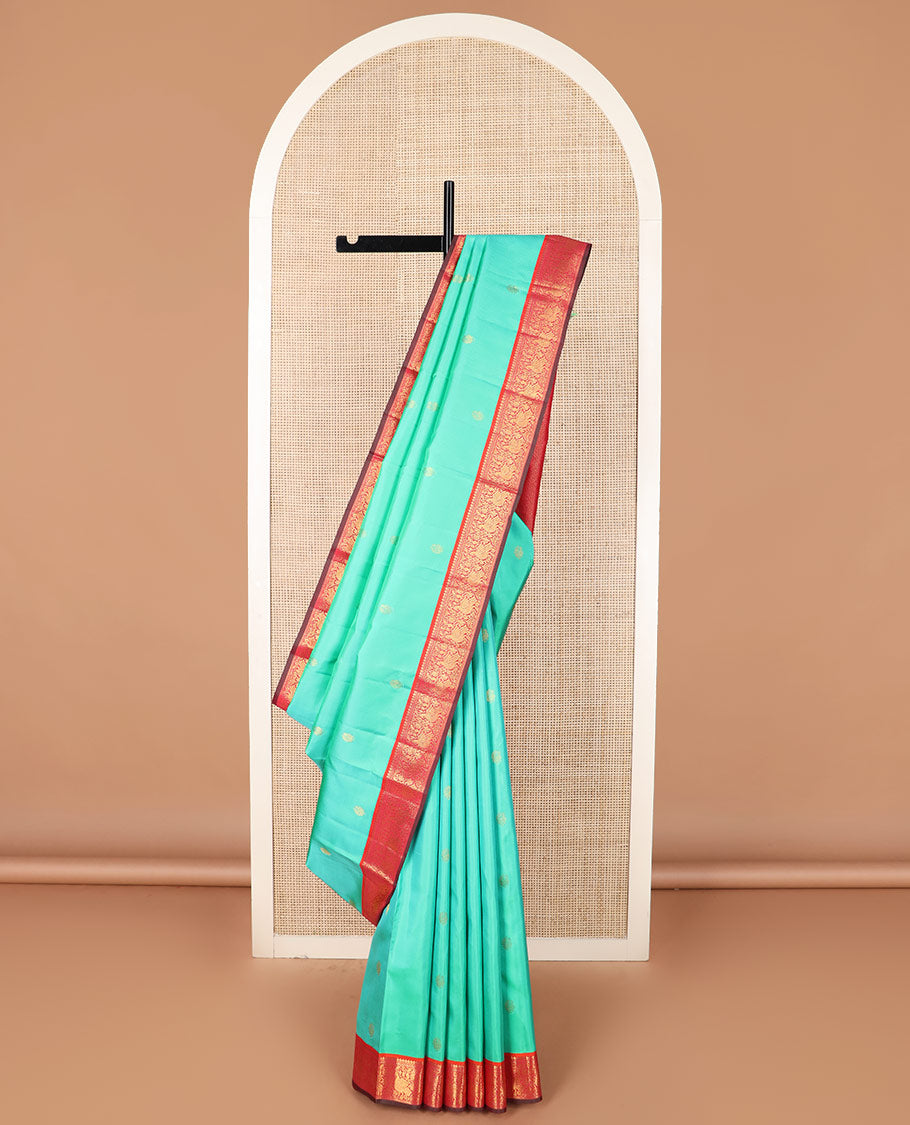 Turquoise mayil buttas silk saree, contrast border of thilakam mokku, muthu, and mayil designs, and jaal pallu