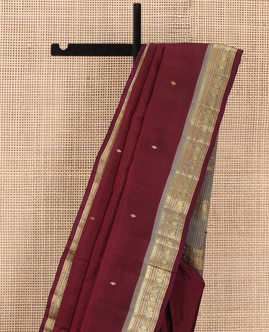 Maroon Kanchipuram Silk Saree Beautified with Vazhaipoo Stripes and Zari Buttas, Complemented by Contrast Border Featuring Manga Mokku, Muthu, Greek Key, and Laddu Kamalam Designs, Sparsely Zari Woven Pallu, and Paired with a Contrast Blouse