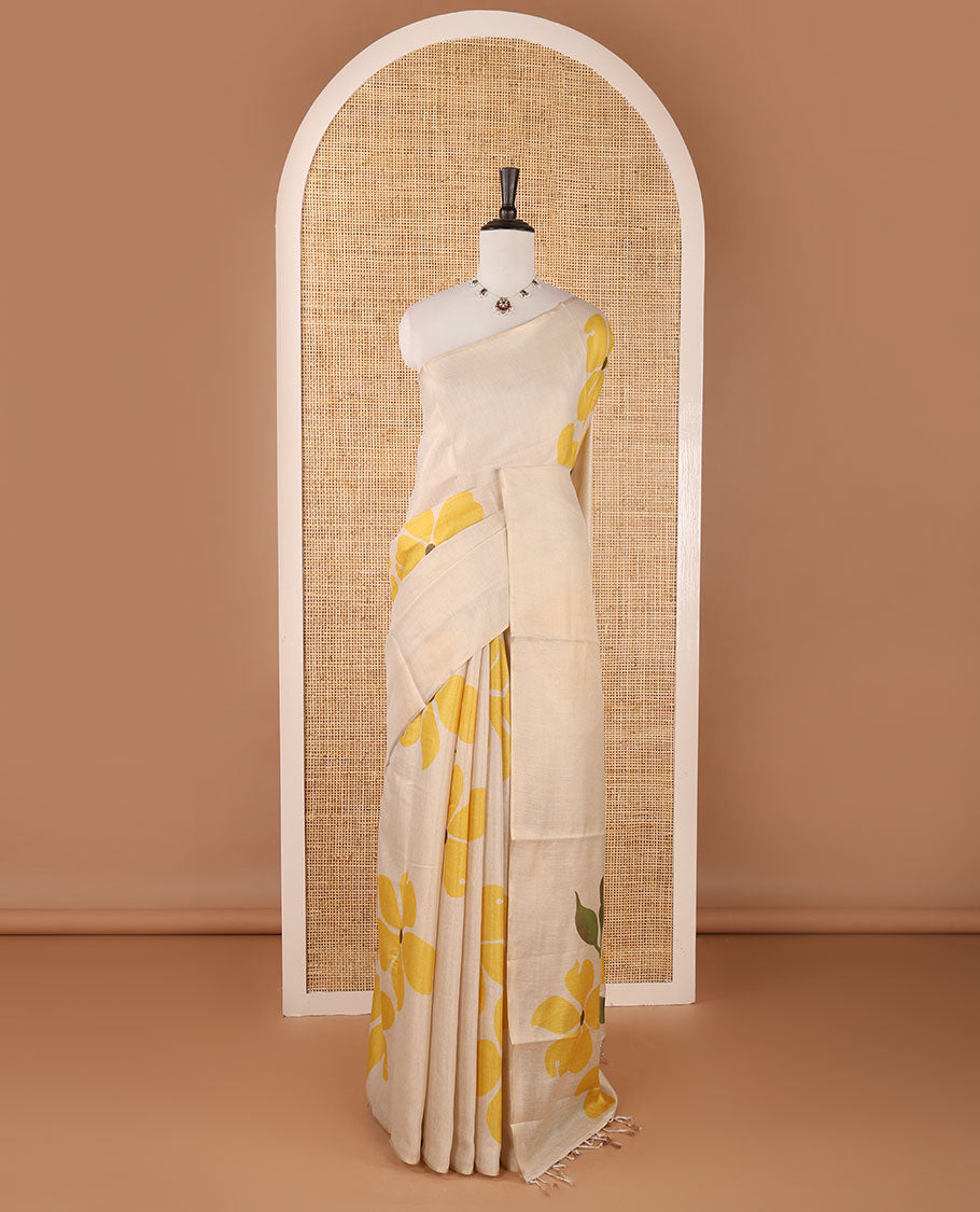 Borderless cream printed onam tissue silk saree features yellow color five-petal flower & leaf motifs print, matching floral print blouse