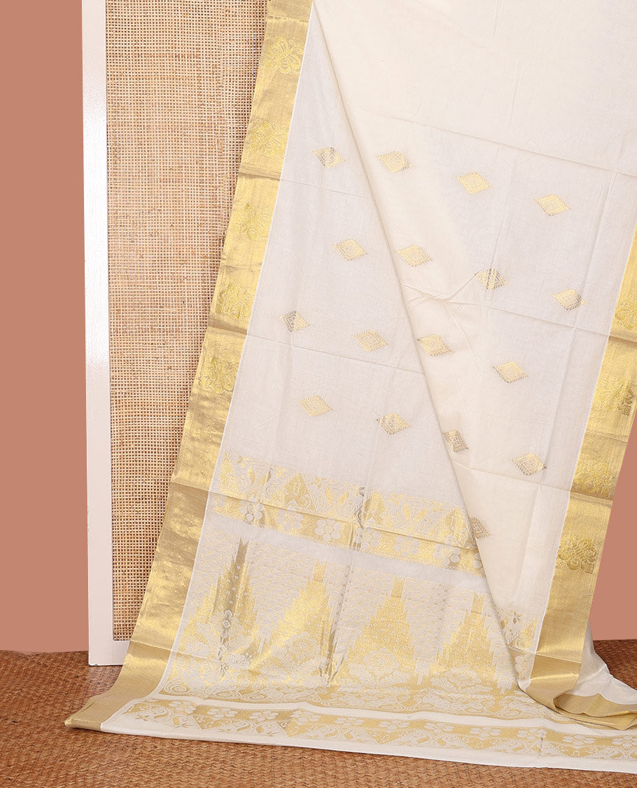 Cream Kerala Cotton Saree Gleamed Up with Zari Buttas All Over Its Body, Scintillating Zari Border, Pallu of Temple and Floral Designs, and Paired with a Matching Blouse
