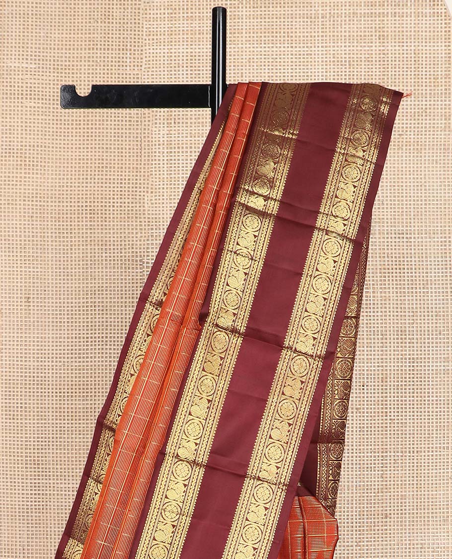 Orange zari checked Kanchipuram silk saree, contrast rettai pettu border of rekku, banaras, neli, and mayil chakram designs, and pallu of lavangam designs
