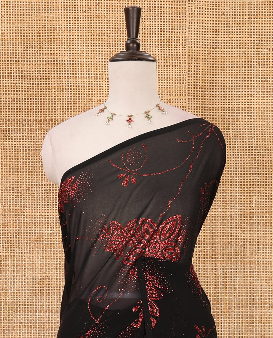 Borderless black 60 gm georgette saree features floral vine designs green glitter embroidery work, contrast plain blouse