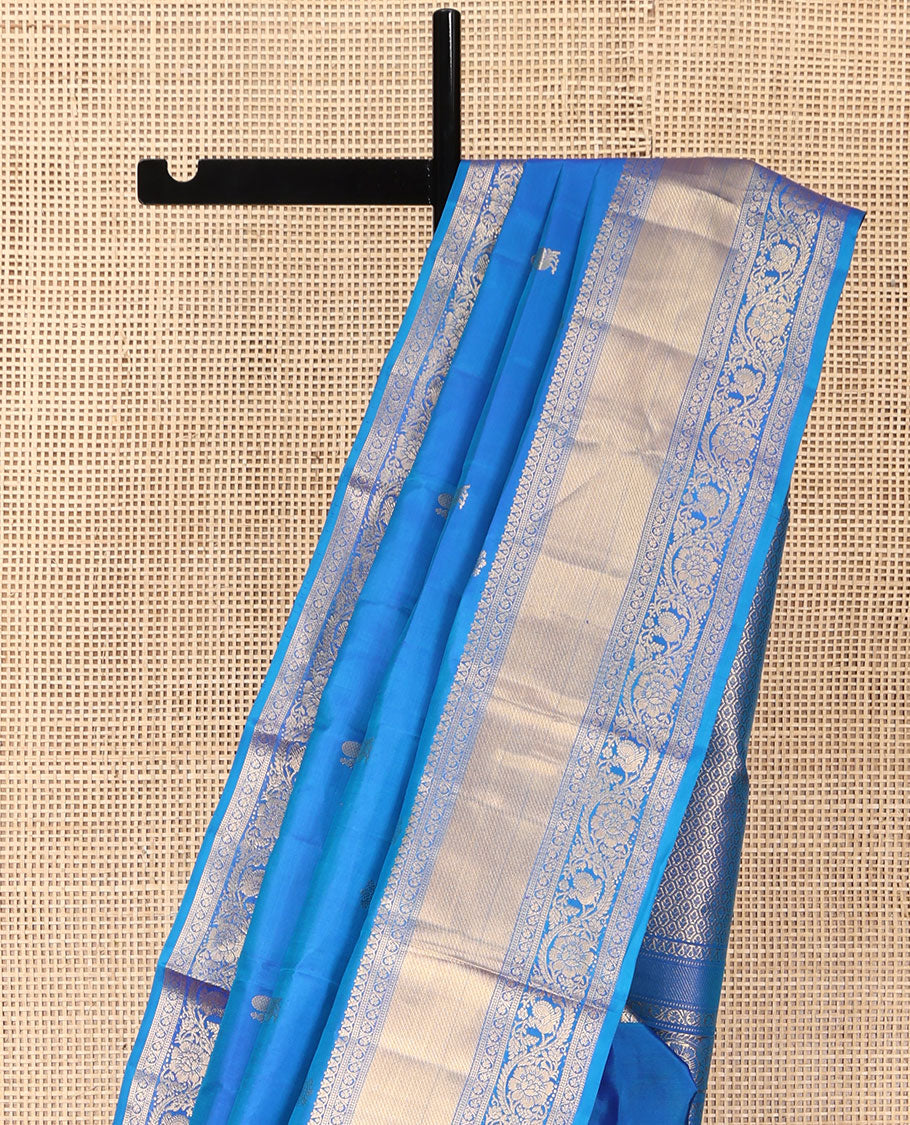 Blue Vasundhara Silk Saree, Mesmerized with Zari Buttas All Over Its Body, Highlighted by a Zari Border of Kodi Visiry, and Mayil Designs, Grand Jaal Pallu, and Paired with a Matching Blouse