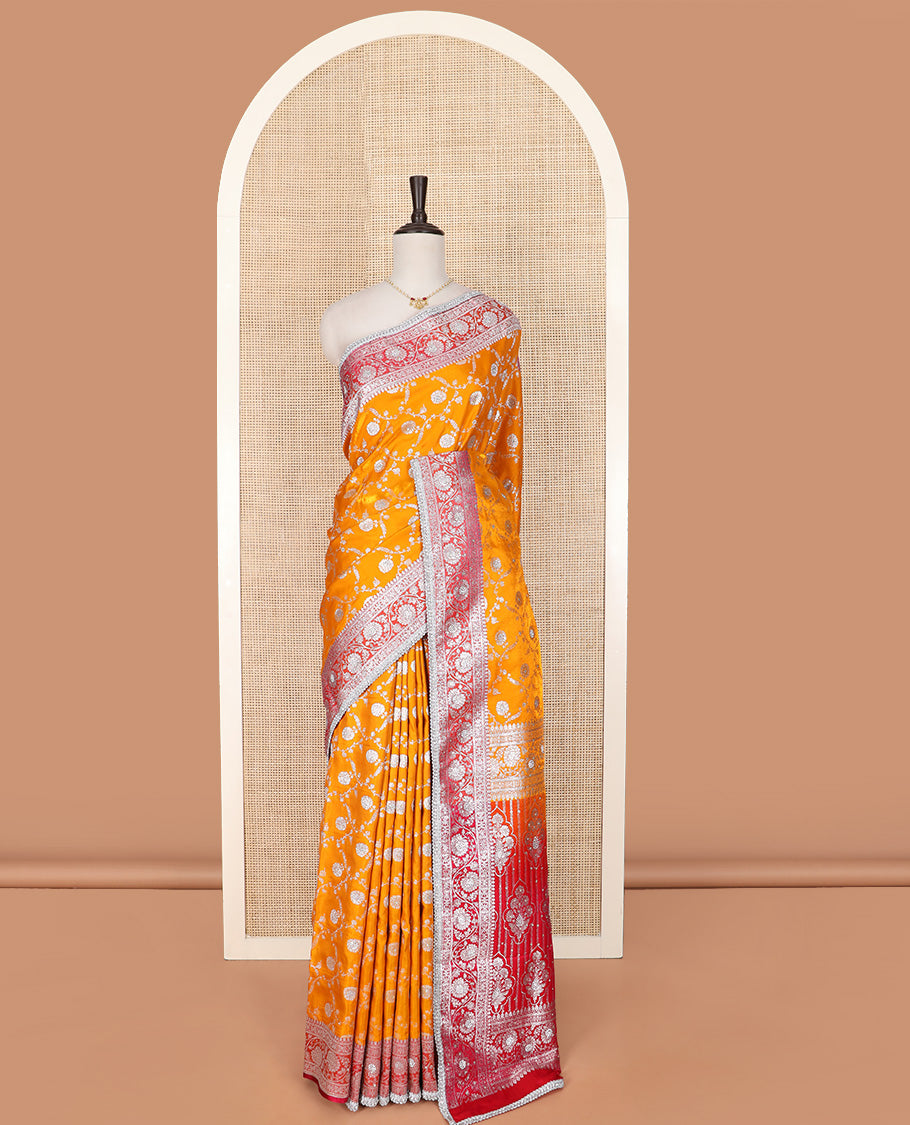 Orange Semi-Banaras Nylon Saree Highlighted with Floral Jaal Jacquard and Stone Work, Complemented by a Contrast Floral Creeper Zari Stone Work Lace Border, Floral Bouquets Themed Pallu Detailed in Zari and Stone Work, and Paired with a Contrast Blouse