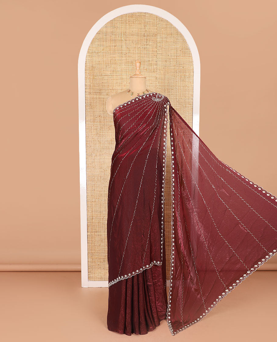 Maroon micro-stone work fendy chiffon saree with paisley stone work on its shoulder, a scallop stone work border, a butterfly style pallu, and a matching stone work blouse