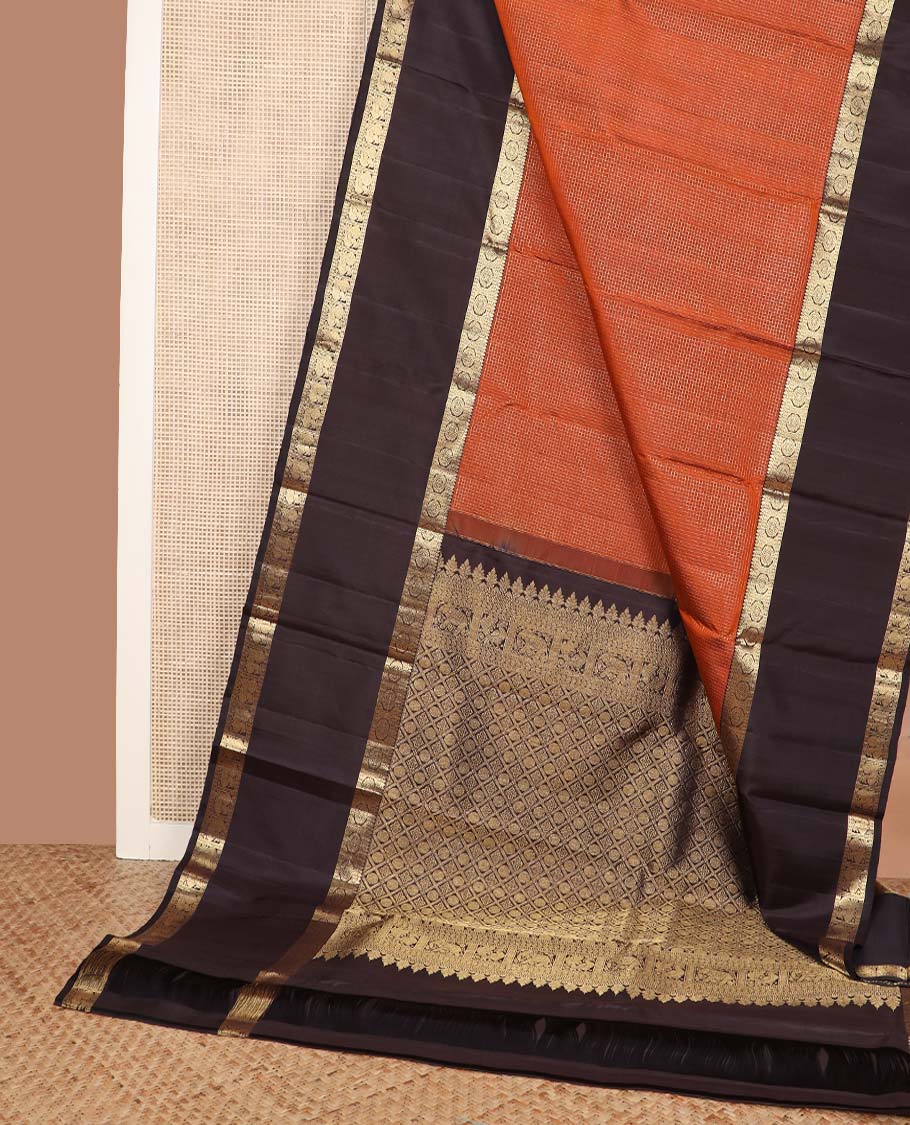 Orange micro-zari checked Kanchipuram silk saree, contrast rettai pettu border of thilakam mokku, rudraksham, and poo chakram and mayil designs, and buttas enclosed jaal pallu