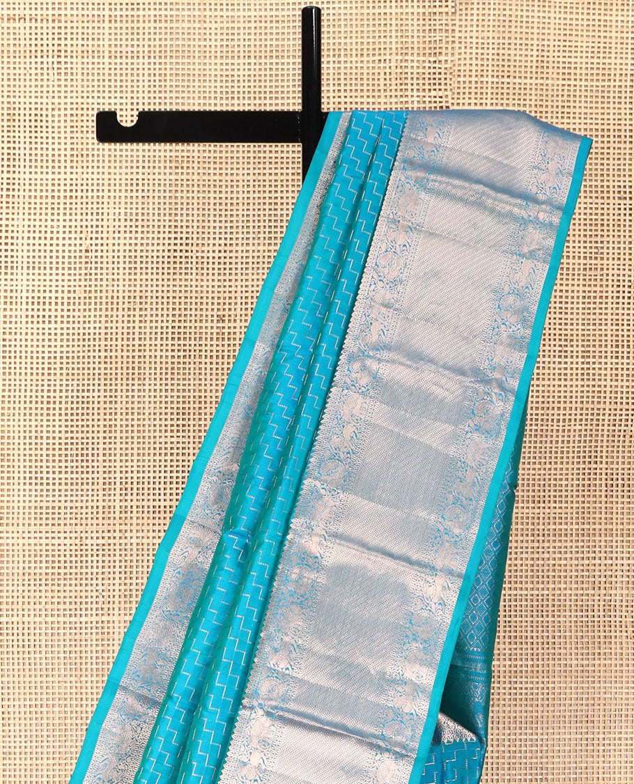 Blue Vasundhara Silk Saree, Beautifully Bedecked with Zig-Zag Stripes All Over Its Body, Highlighted by a Zari Border of Rekku, Muthu, Neli, Mayil, and Yaali Designs, Grand Jaal Pallu, and Paired with a Matching Blouse