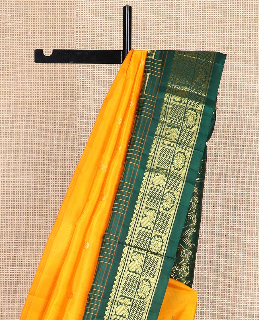 Yellow zari buttas kanchipuram silk saree, contrast one-sided thazampoo rekku checked border of annam chakram & mayil kann & intricate pallu