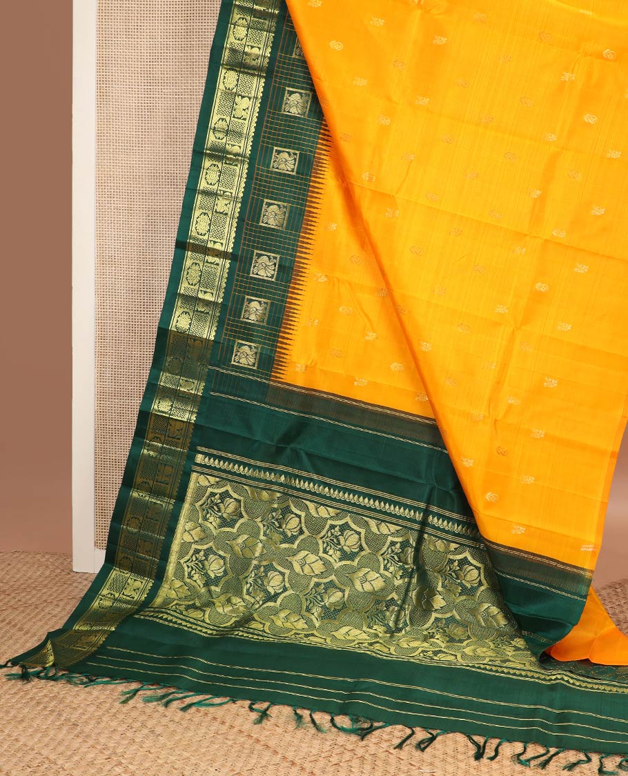 Yellow zari buttas kanchipuram silk saree, contrast one-sided thazampoo rekku checked border of annam chakram & mayil kann & intricate pallu
