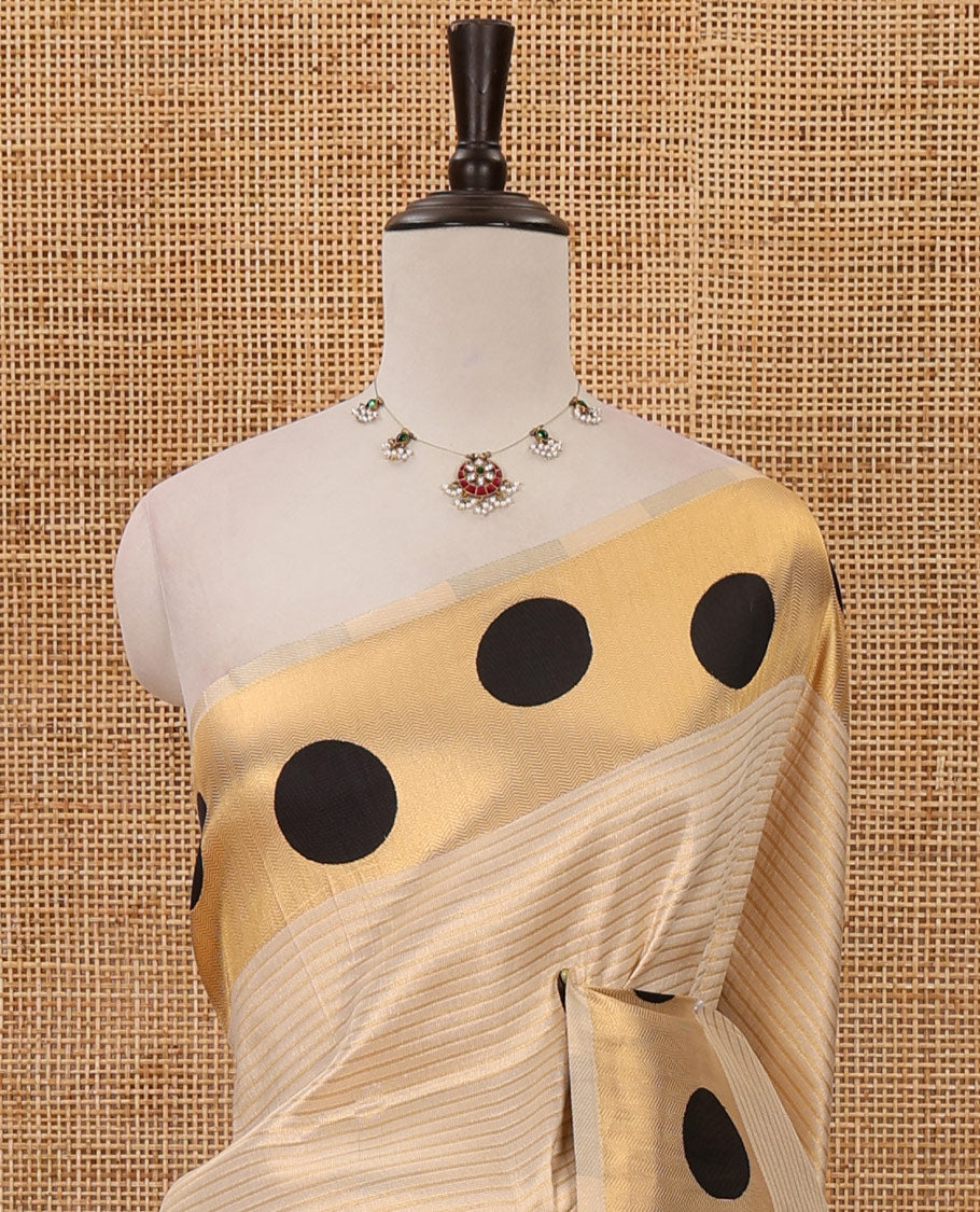 Cream golden zari striped banarasi tissue saree, zari vanki border & pallu of small black polka dot designs, plain blouse