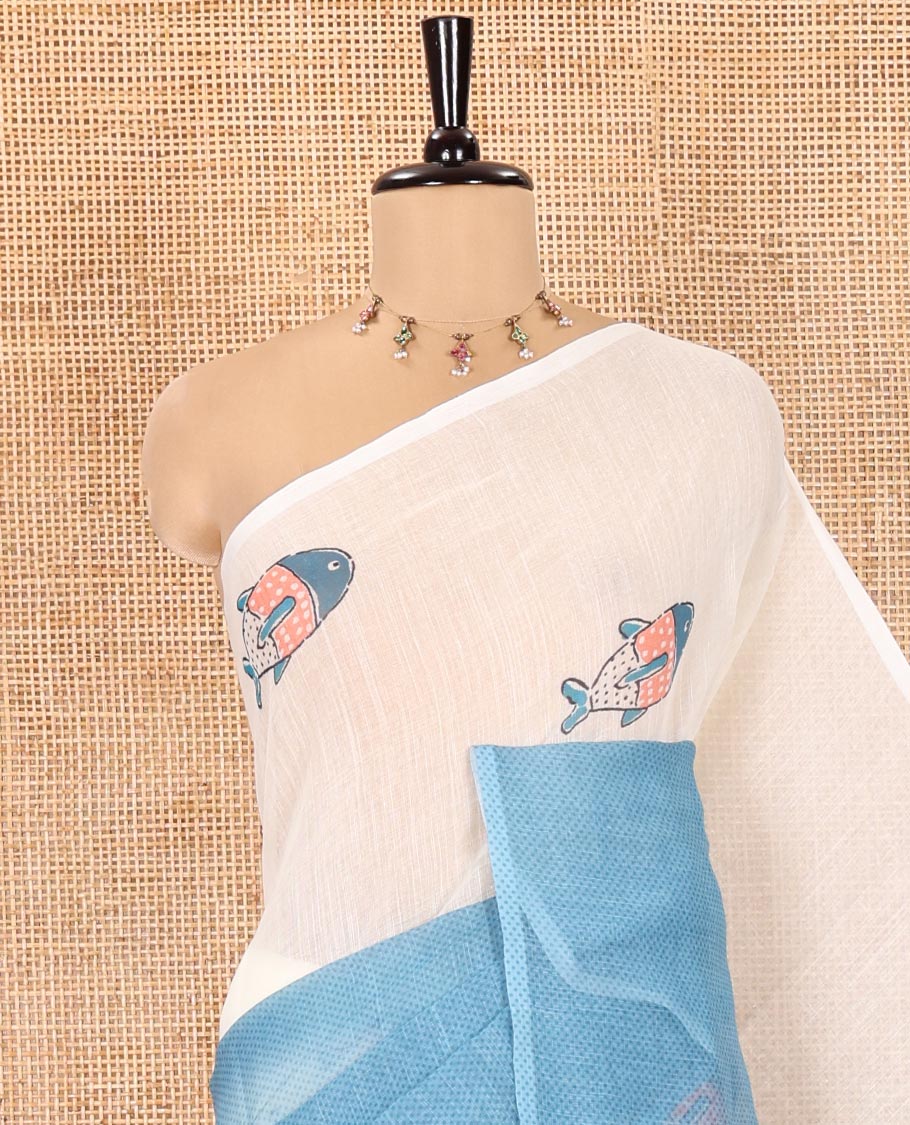 Borderless Cream and Blue Linen Cotton Saree, Accentuated with Half-and-Half Style Fish Motifs Printed All Over Its Body, Pallu Mirrors the Same Print, and Is Paired with a Contrast Blouse