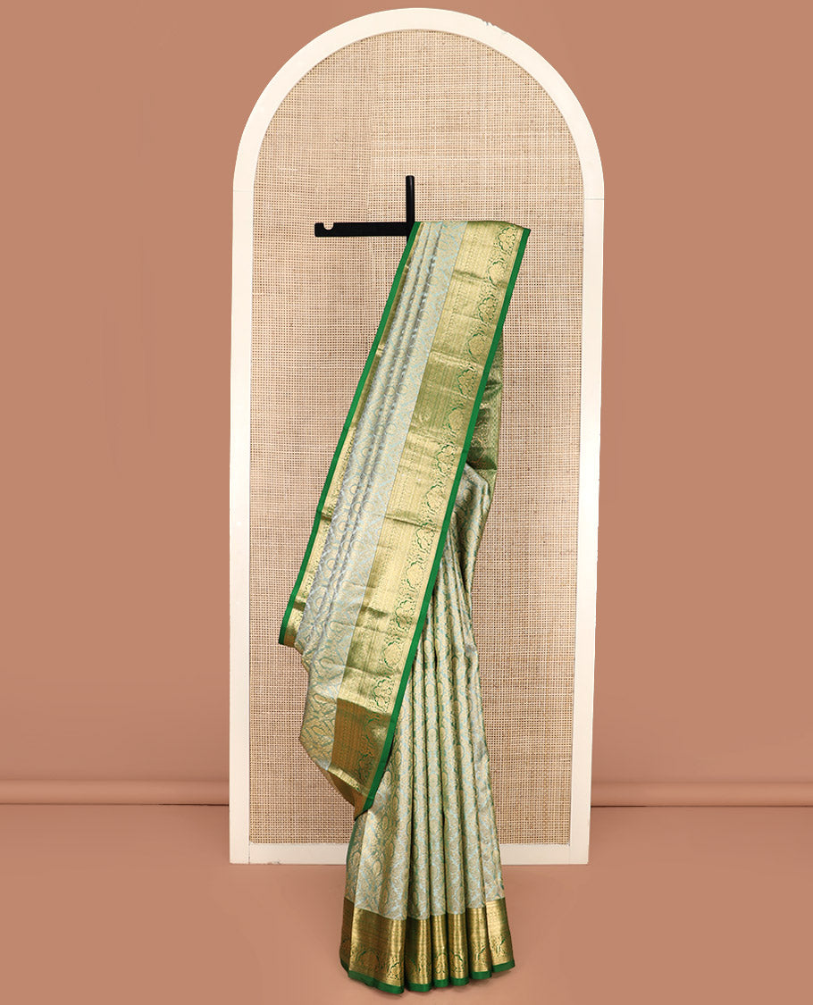 Green Kanchipuram Silk Saree Embellished with Jacquard Design, Highlighted by a Contrast Border of Thilakam, Muthu, Rekku, Manga, Chakram, and Floral Designs, Majestically Woven Pallu Steeped with Chakram Designs, and Paired with a Matching Blouse