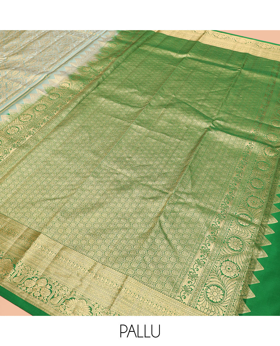 Green Kanchipuram Silk Saree Embellished with Jacquard Design, Highlighted by a Contrast Border of Thilakam, Muthu, Rekku, Manga, Chakram, and Floral Designs, Majestically Woven Pallu Steeped with Chakram Designs, and Paired with a Matching Blouse