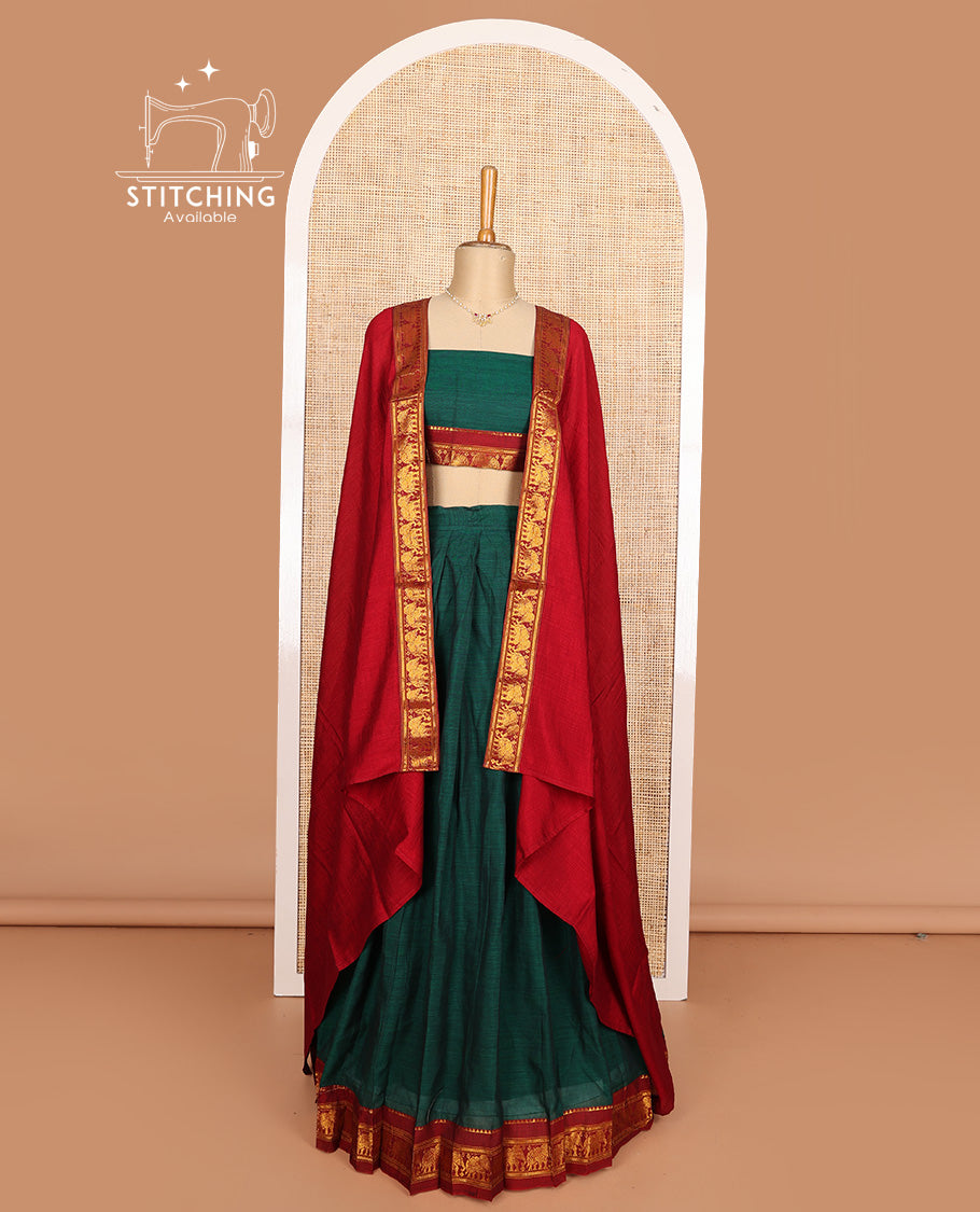 Green cotton half-saree, plain with contrast elephant motif bordered skirt, matching blouse, and contrast elephant motif bordered dhavani