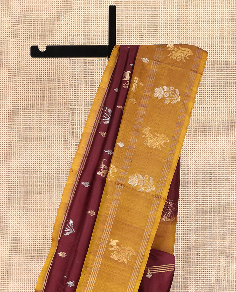 Maroon Uppada Silk Saree, Ornamented with Zari Buttas All Over Its Body, Complemented by Contrast Zari Border of Floral Designs, Pallu Steeped with Floral Designs, and Paired with a Contrast Blouse