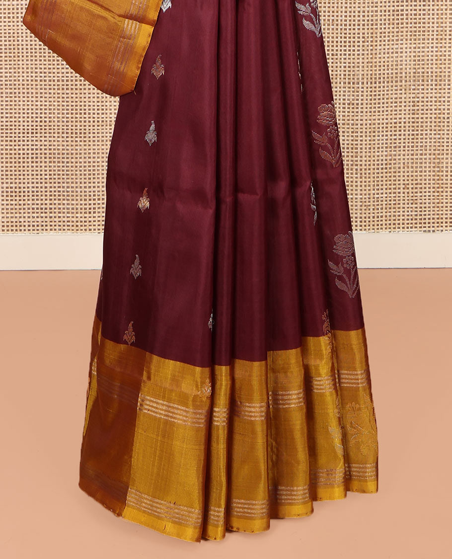 Maroon Uppada Silk Saree, Ornamented with Zari Buttas All Over Its Body, Complemented by Contrast Zari Border of Floral Designs, Pallu Steeped with Floral Designs, and Paired with a Contrast Blouse