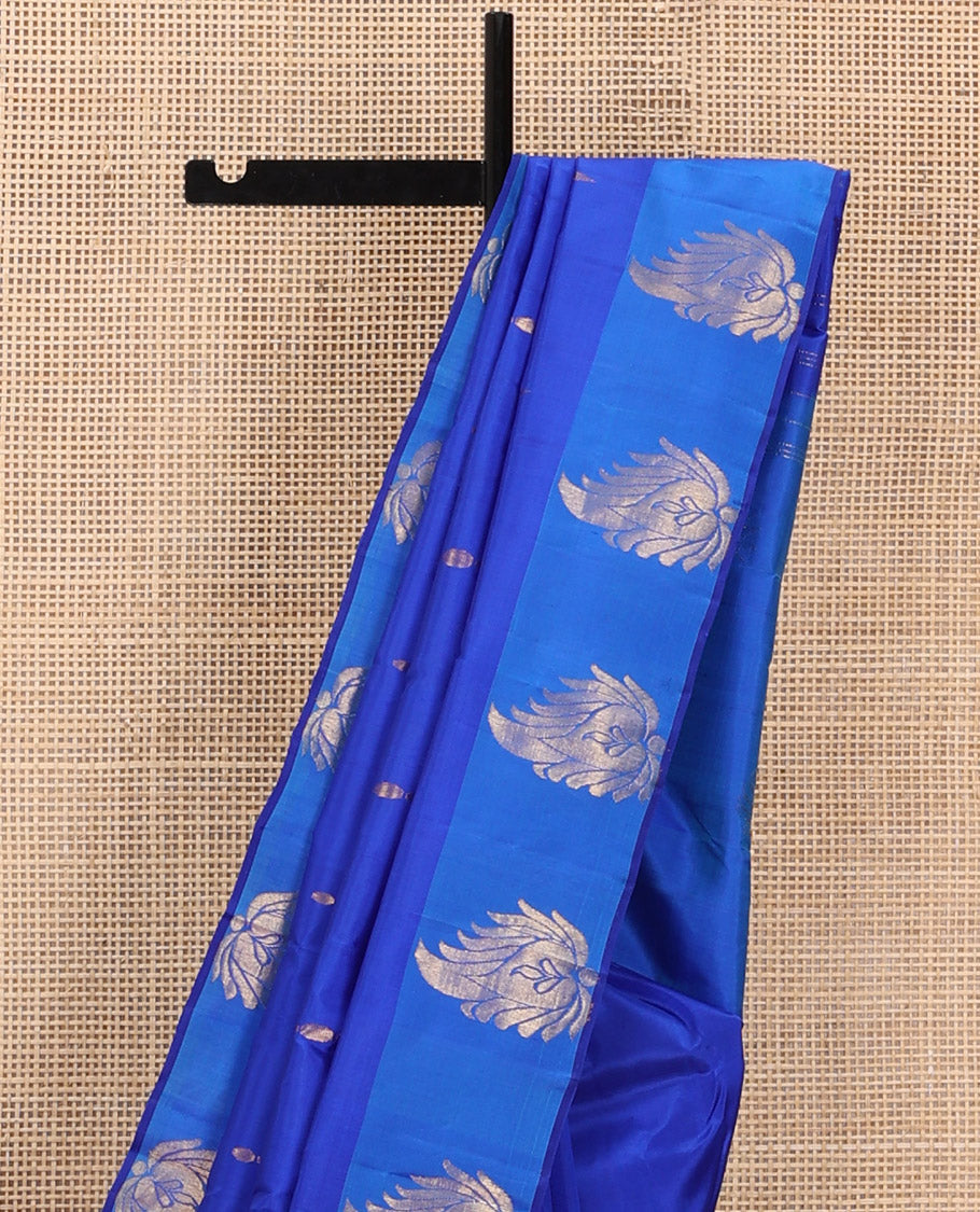 Royal Blue Kanchipuram Silk Saree Adorned with Zari Buttas, Complemented by a Contrast Border of Leaf Zari Designs, Sparsely Zari Woven Pallu, and Paired with a Contrast Blouse