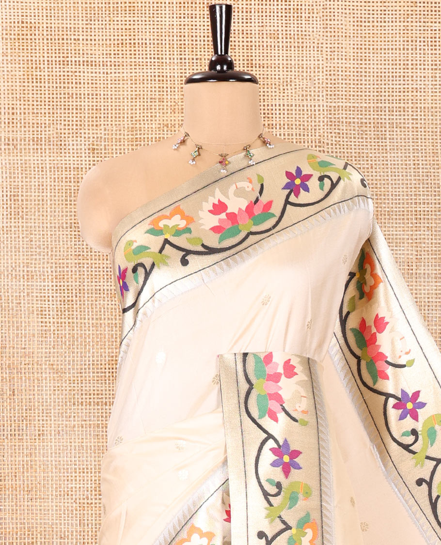 Half-White Paithani Art Silk Saree, Enthralled with Flower Buttas All Over Its Body, Highlighted by Zari Border Pictures Colorful Floral, and Parrot Designs, Pallu of Muniya, Floral and Parrot Designs, and Paired with a Matching Blouse