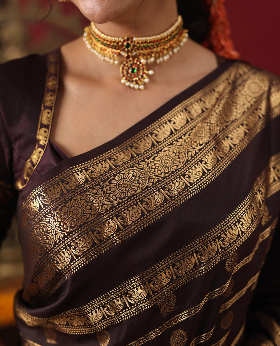 Brown Vasundhara Silk Saree, Enriched with Annam Chakram Buttas and Zari Stripes, Highlighted by Zari Rettai Pettu Border of Ara Bogudi, Muthu, Banaras, Yaanai, and Chakram Designs, Gleaming Jaal Design Woven Pallu, and Paired with a Matching Blouse