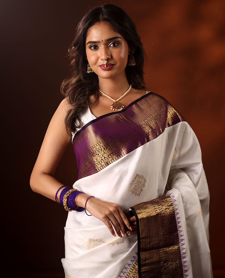 White Silk Saree Highlighted with All-Over Zari Buttas, Contrast Border Features Thazampoo Rekku, Yaanai, Mayil, and Muthu Designs, with a Zari-Enriched Jaal Pallu