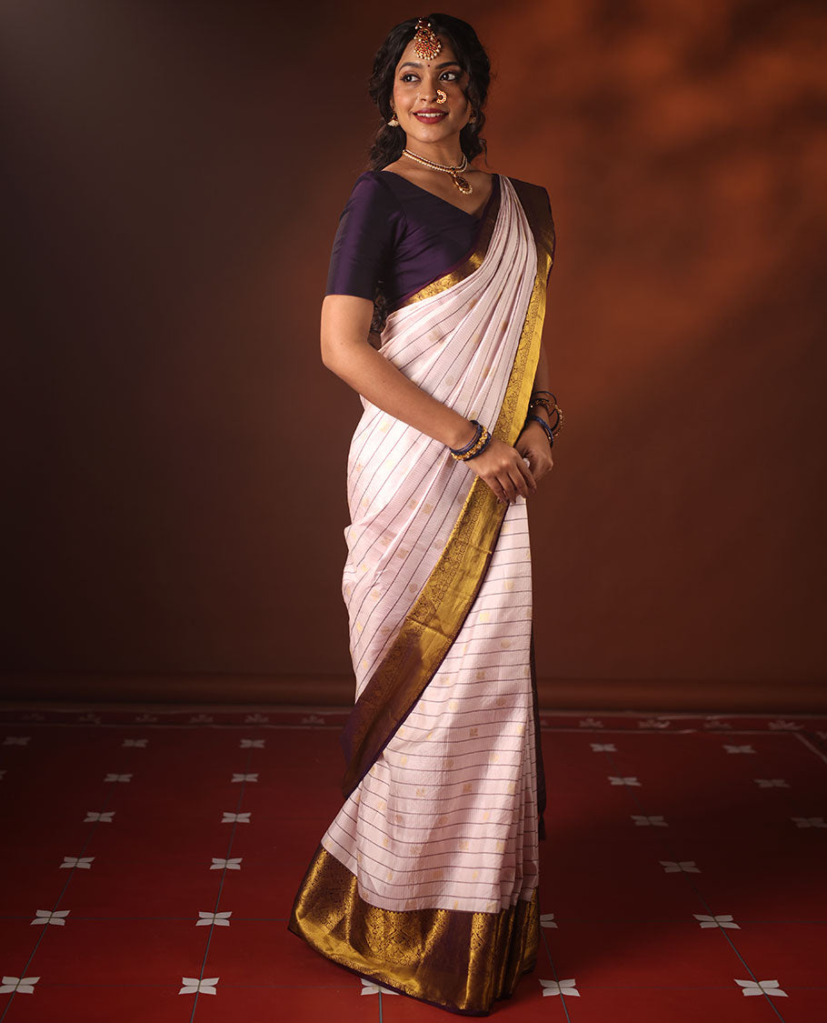 White silk saree adorned with Mayil Chakram, Neli, and Muthu stripes, featuring a contrast border with Laddu Kamalam, Mayil, Yaali, and Mayil Kann designs, along with a Jaal design pallu
