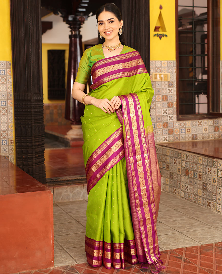 Parrot Green Vasundhara Silk Saree Richly Detailed with Zari Buttas, Complemented with Varisai Pettu Border Featuring Rekku, Muthu, Banaras, Rudraksham, and Mayil Designs, Majestically Zari Woven Pallu, and a Contrast Blouse