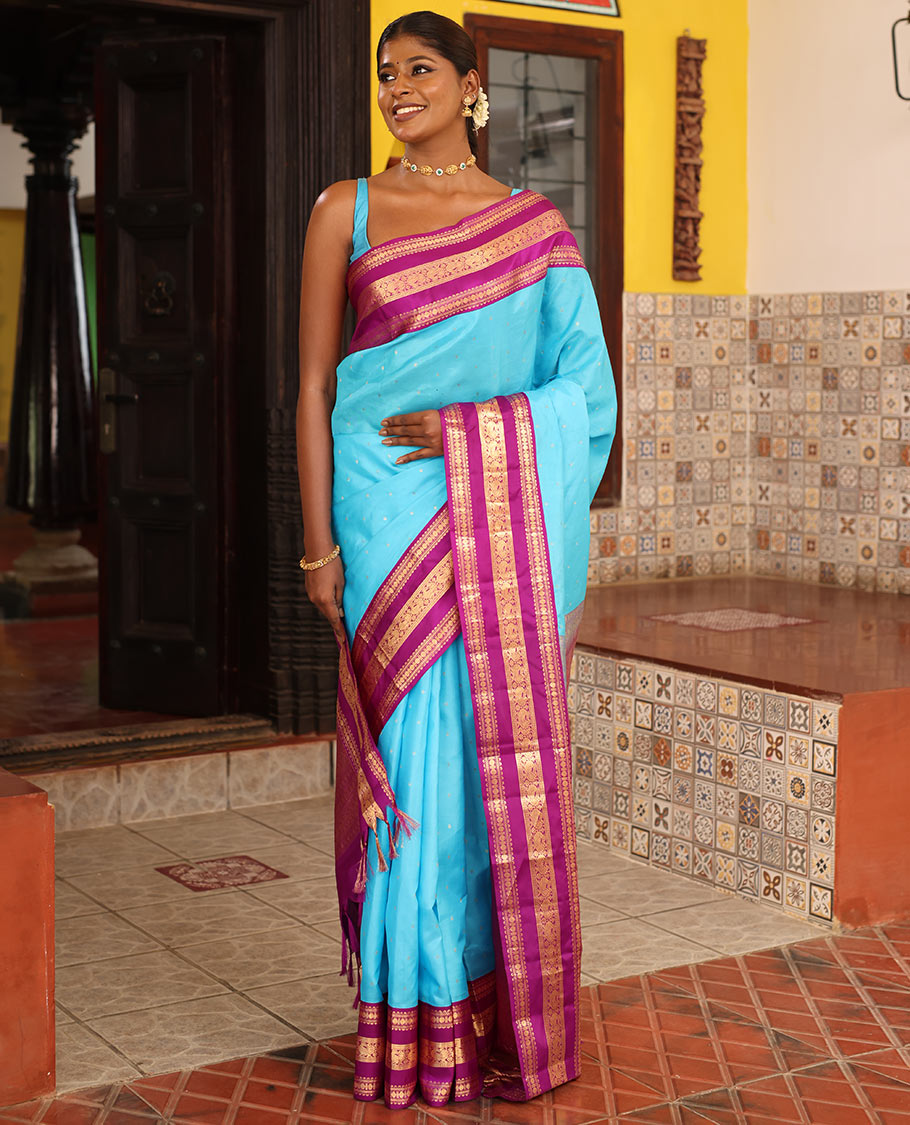 Blue Vasundhara Silk Saree Gracefully Embellished with Zari Buttas, Complemented by a Varisai Pettu Border Featuring Rekku, Muthu, Banaras, Rudraksham, and Mayil Designs, Majestically Woven with a Zari-Designed Pallu, and Paired with a Contrast Blouse
