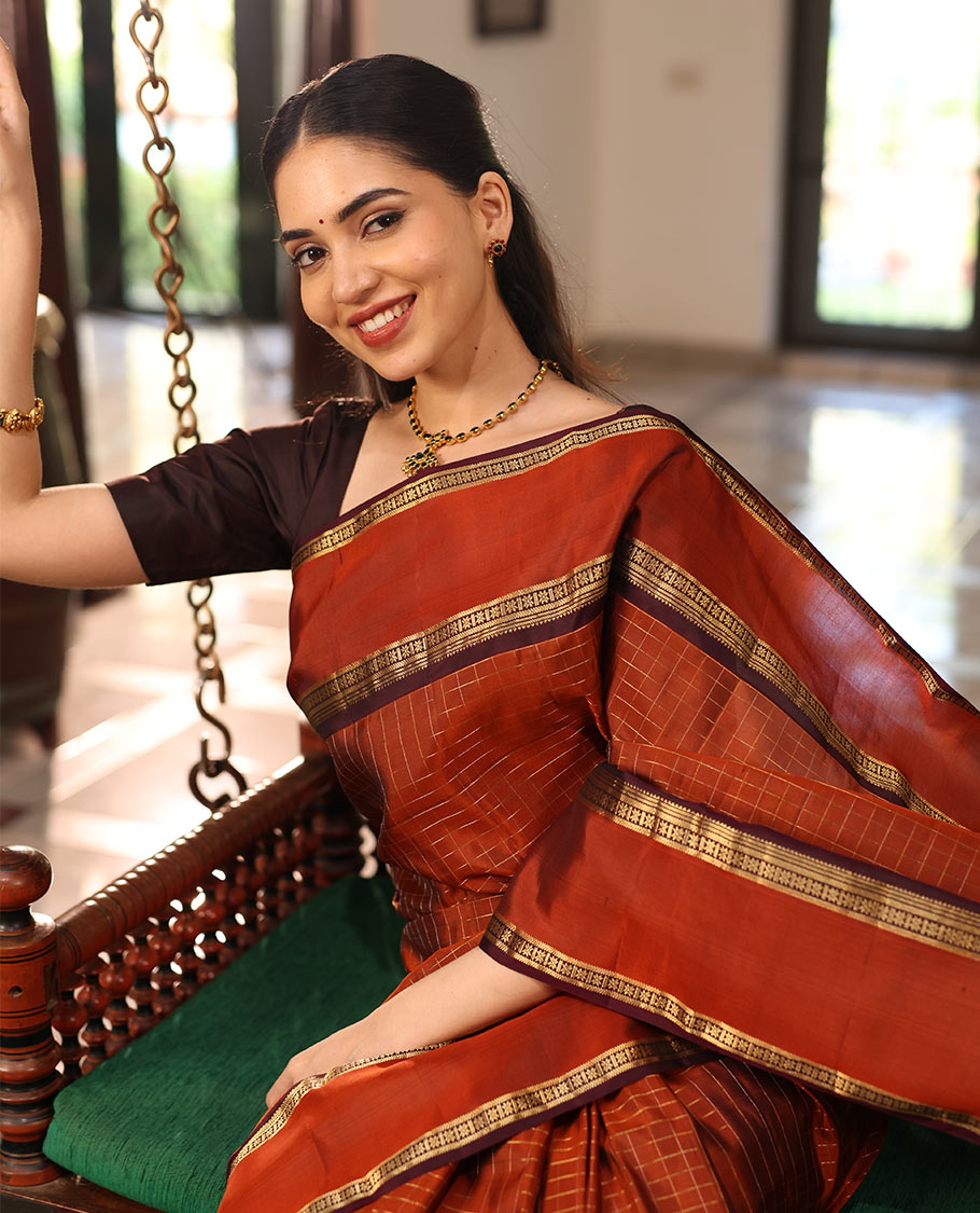 Rust Orange Kanchipuram Soft Silk Saree Graced with Medium-sized Zari Checks, Complemented by a Contrast Rettai Pettu Border of Rekku, Banaras, Kathir, and Star Vanki Designs, Pallu Elevated with Zari Designs, and Paired with a Contrast Blouse