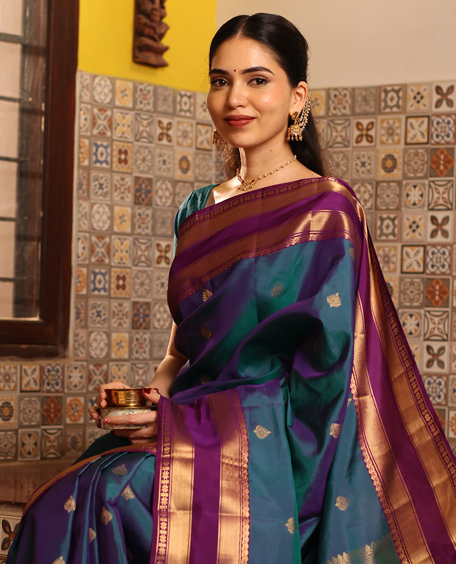 Blue Vasundhara Silk Saree Decked with Zari Buttas, Delicately Woven with a Contrast Rettai Pettu Border Featuring Thilakam Mokku, Vanki, Mayil Kann, and Star Motifs, a Majestically Woven Jaal-Designed Pallu, Paired with a Zari-Designed Blouse