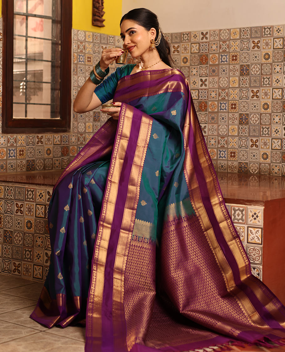 Blue Vasundhara Silk Saree Decked with Zari Buttas, Delicately Woven with a Contrast Rettai Pettu Border Featuring Thilakam Mokku, Vanki, Mayil Kann, and Star Motifs, a Majestically Woven Jaal-Designed Pallu, Paired with a Zari-Designed Blouse