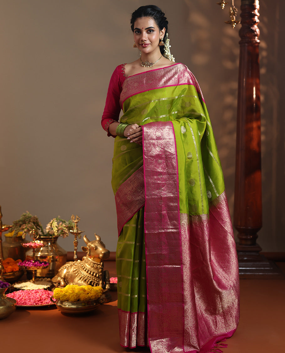 Parrot Green Vasundhara Silk Saree Featuring Veldhari and Round Kuthirai Motifs, Complemented by a Contrast Border of Thilakam Mokku, Muthu, Annam Chakram, and Kodi Visiry Designs, Pallu Elevated with Floral Designs, and Paired with a Contrast Blouse
