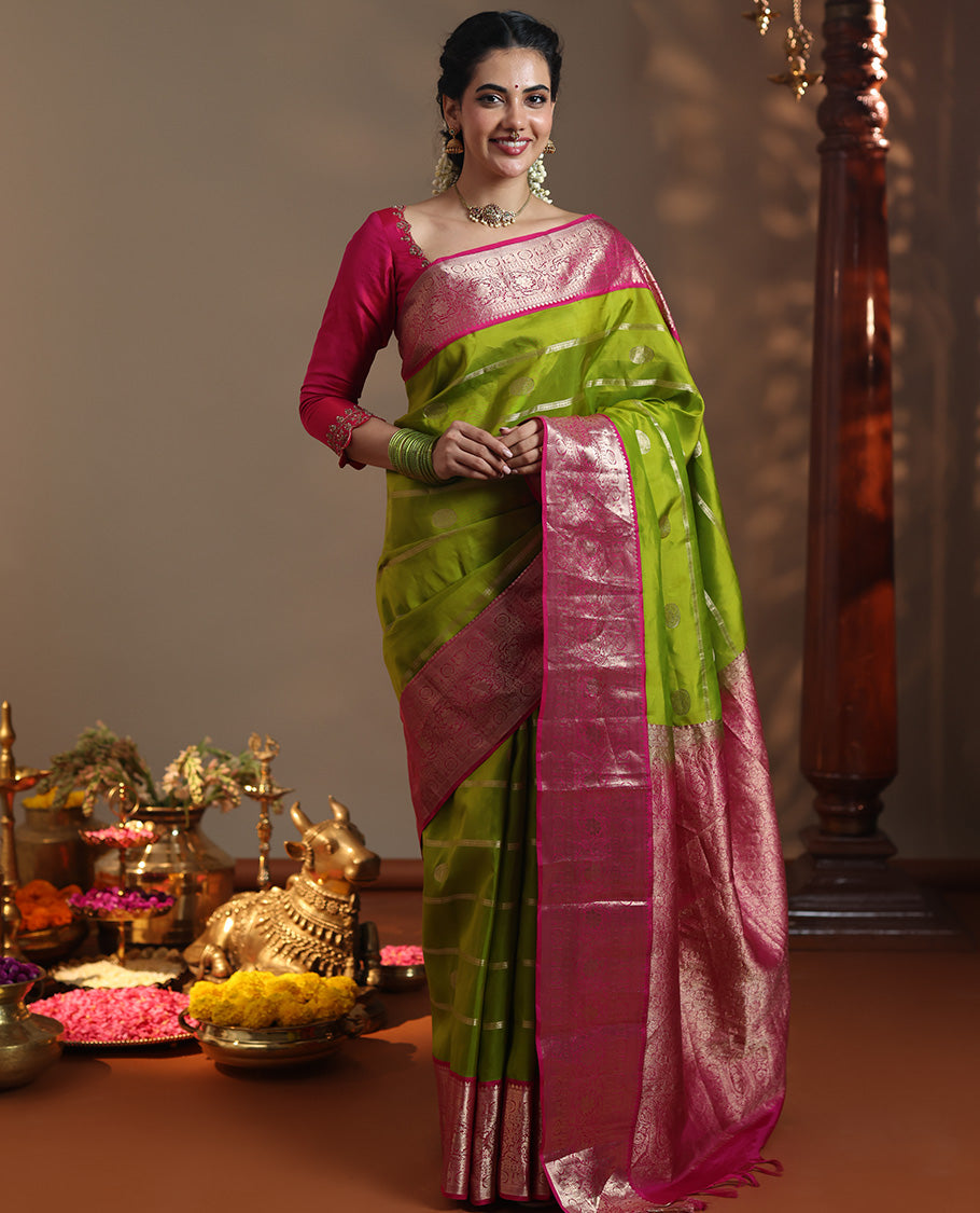 Parrot Green Vasundhara Silk Saree Featuring Veldhari and Round Kuthirai Motifs, Complemented by a Contrast Border of Thilakam Mokku, Muthu, Annam Chakram, and Kodi Visiry Designs, Pallu Elevated with Floral Designs, and Paired with a Contrast Blouse