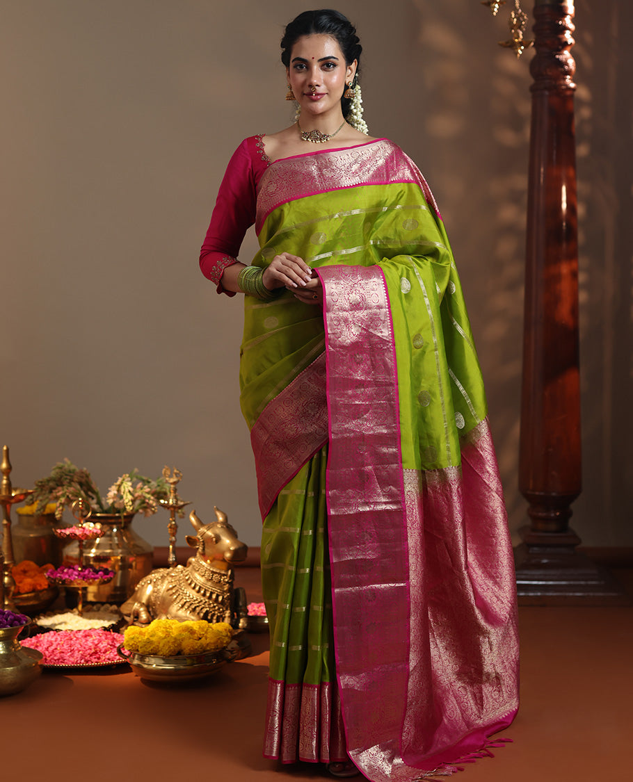 Parrot Green Vasundhara Silk Saree Featuring Veldhari and Round Kuthirai Motifs, Complemented by a Contrast Border of Thilakam Mokku, Muthu, Annam Chakram, and Kodi Visiry Designs, Pallu Elevated with Floral Designs, and Paired with a Contrast Blouse