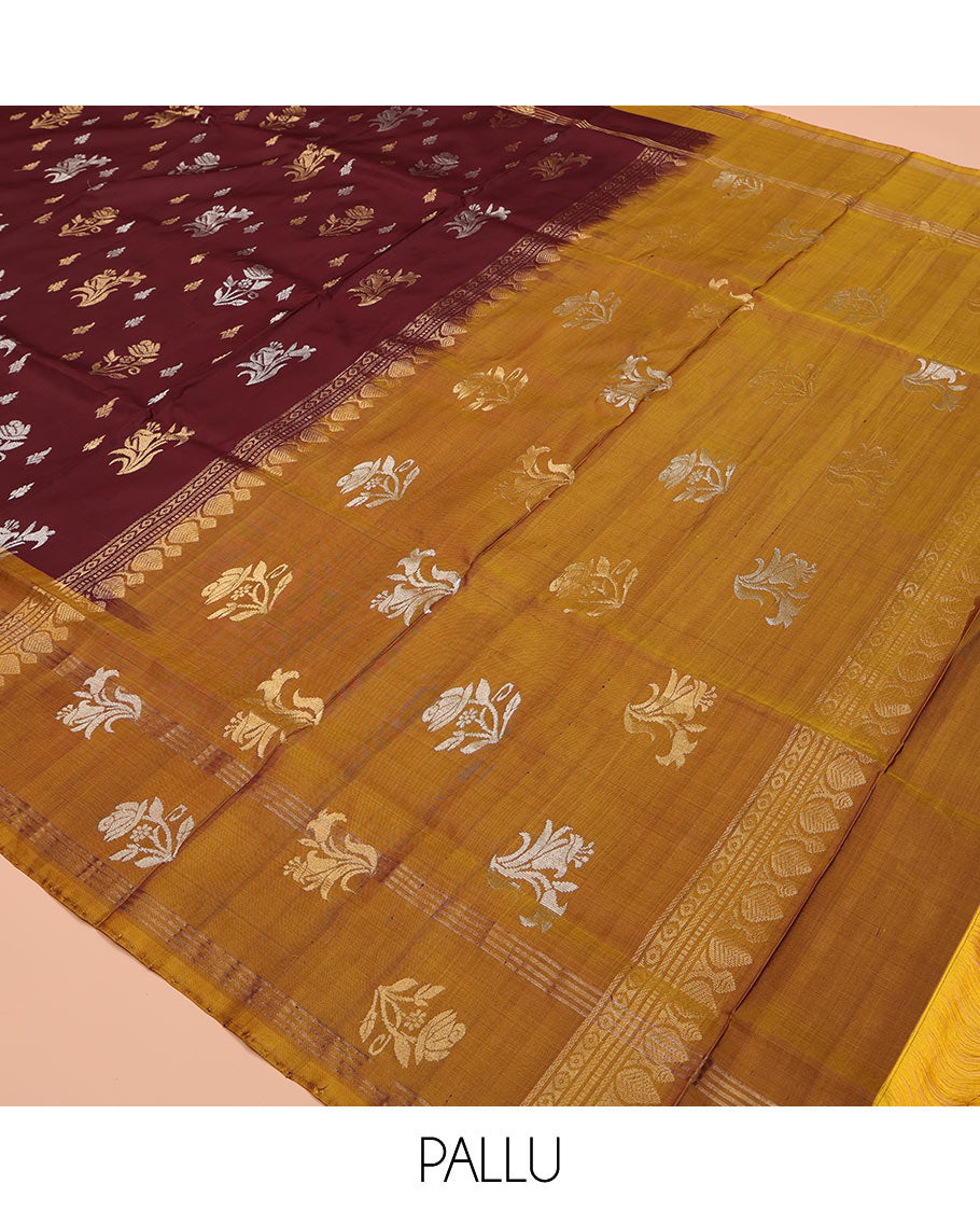Maroon Uppada Silk Saree, Ornamented with Zari Buttas All Over Its Body, Complemented by Contrast Zari Border of Floral Designs, Pallu Steeped with Floral Designs, and Paired with a Contrast Blouse