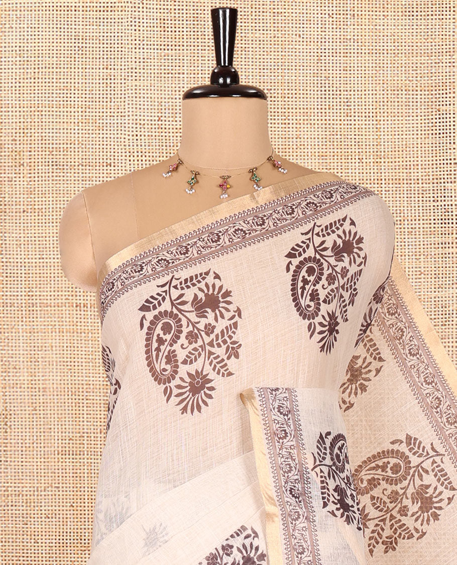 Chikku Linen Cotton Saree, Delicately Designed with Floral-Paisley Motifs Print All Over Its Body, Highlighted by Gold Zari Printed Border, Floral-Paisley Printed Pallu and Paired with a Matching Blouse