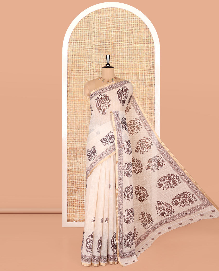 Chikku Linen Cotton Saree, Delicately Designed with Floral-Paisley Motifs Print All Over Its Body, Highlighted by Gold Zari Printed Border, Floral-Paisley Printed Pallu and Paired with a Matching Blouse
