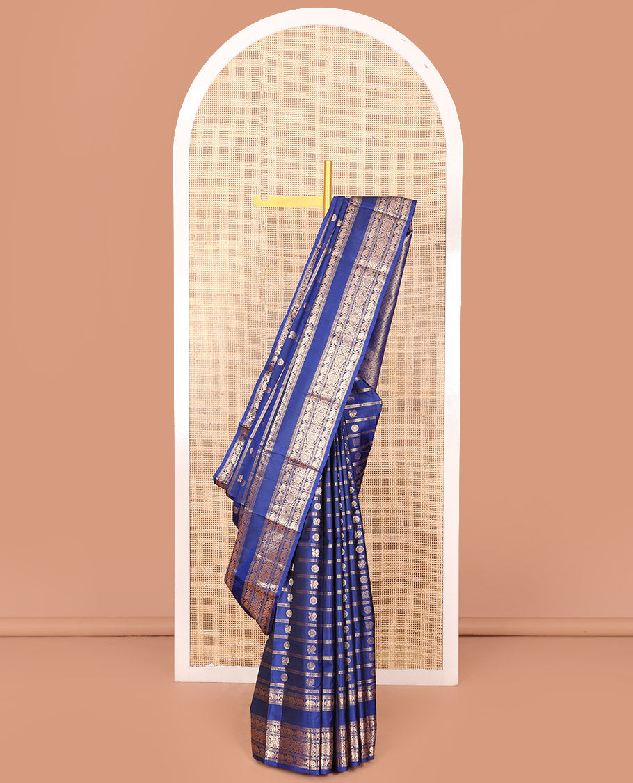 Blue Vasundhara Silk Saree Adorned with Zari Stripes and Annam Chakram Buttas, Highlighted by a Zari Border of Ara Bogudi, Muthu, Banaras, Yaanai, and Chakram Designs, a Zari-Woven Pallu of Jaal Designs, and Paired with a Matching Blouse