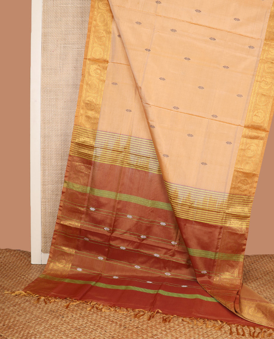 Sandal Banana Pith Saree, Highlighted by Buttas All Over Its Body, Complemented by a Contrast Traditional Zari Border of Peacock-Chakram Designs, Pallu Features Stripes, and Paired with a Contrast Blouse