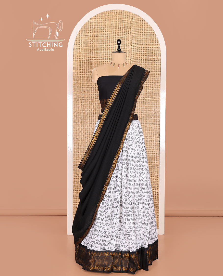 White and Black Printed Sungudi Cotton Half-Saree Showcasing a Skirt Printed with Tamil Letters, Accentuated by a Contrast Traditional Zari Border, a Contrast Blouse, and a Plain Zari-Bordered Dhavani