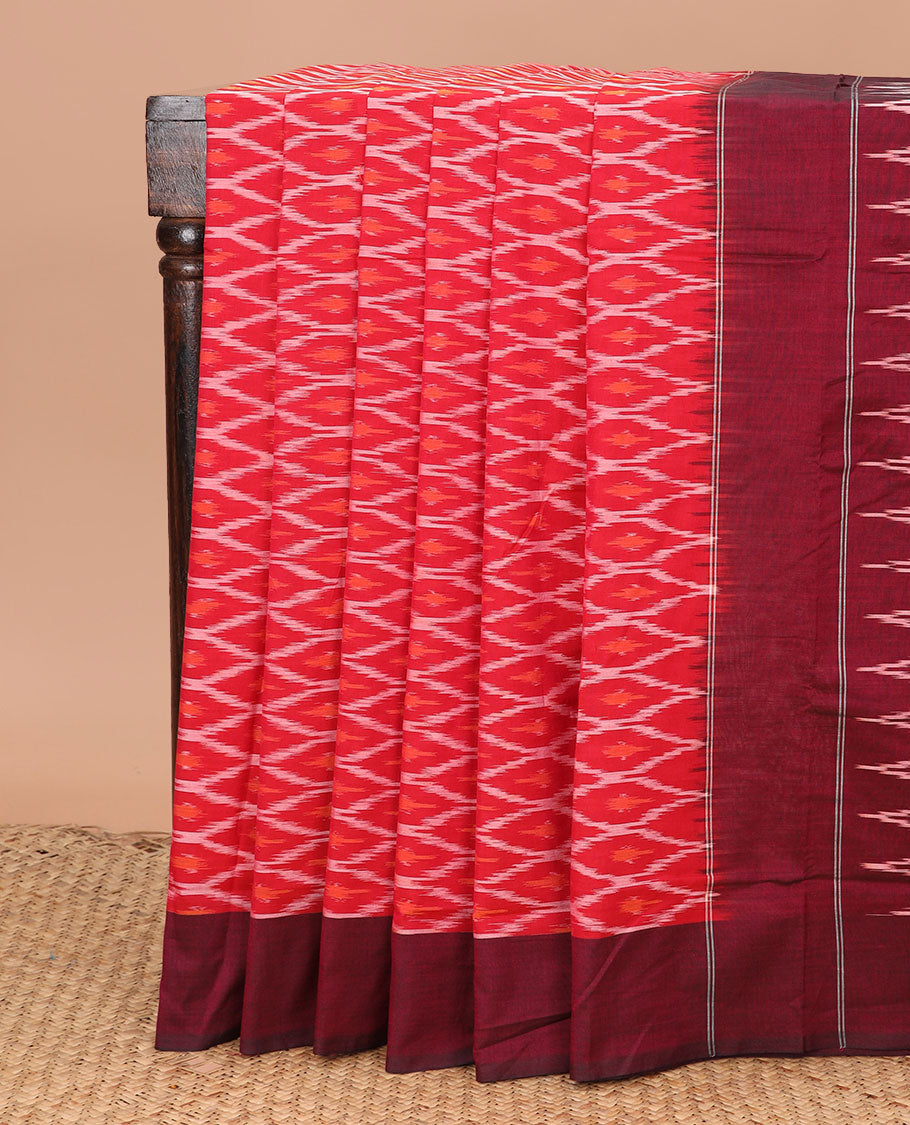 Red Ikkat Cotton Saree Delicately Woven with Ogee Patterns in Ikkat Weave, Complemented by a Contrast Plain Border, and Pallu Featuring Ikkat Buttas