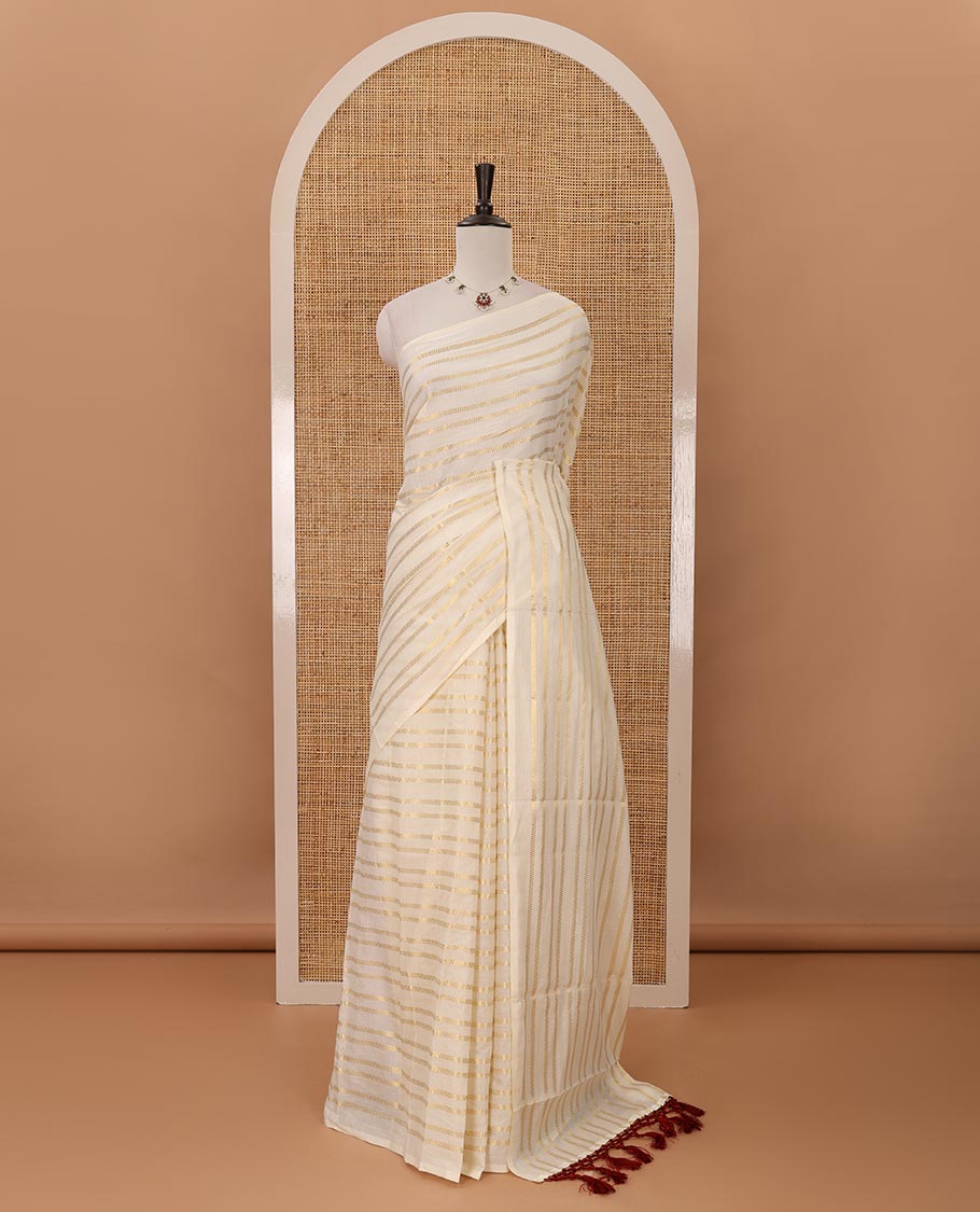 Borderless cream Veldhari-style striped Kerala cotton saree, zari design pallu with maroon tussels & zari design blouse