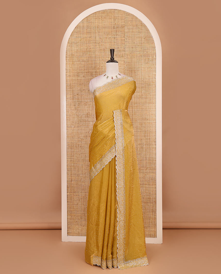 Mustard Swarovski crystal stone embedded fendy chiffon saree, scallop Swarovski stone embroidered border, and contrast plain blouse
