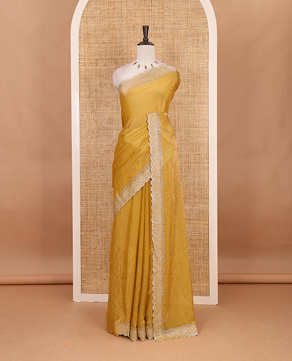 Mustard Swarovski crystal stone embedded fendy chiffon saree, scallop Swarovski stone embroidered border, and contrast plain blouse