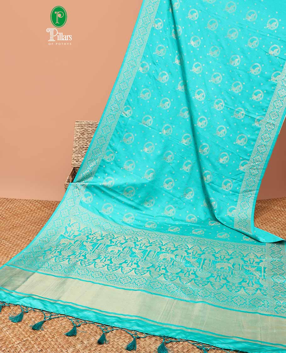 Emerald blue allover embosed with gold zari figure design , zari weaving rich pallu with tussels & self small butta blouse