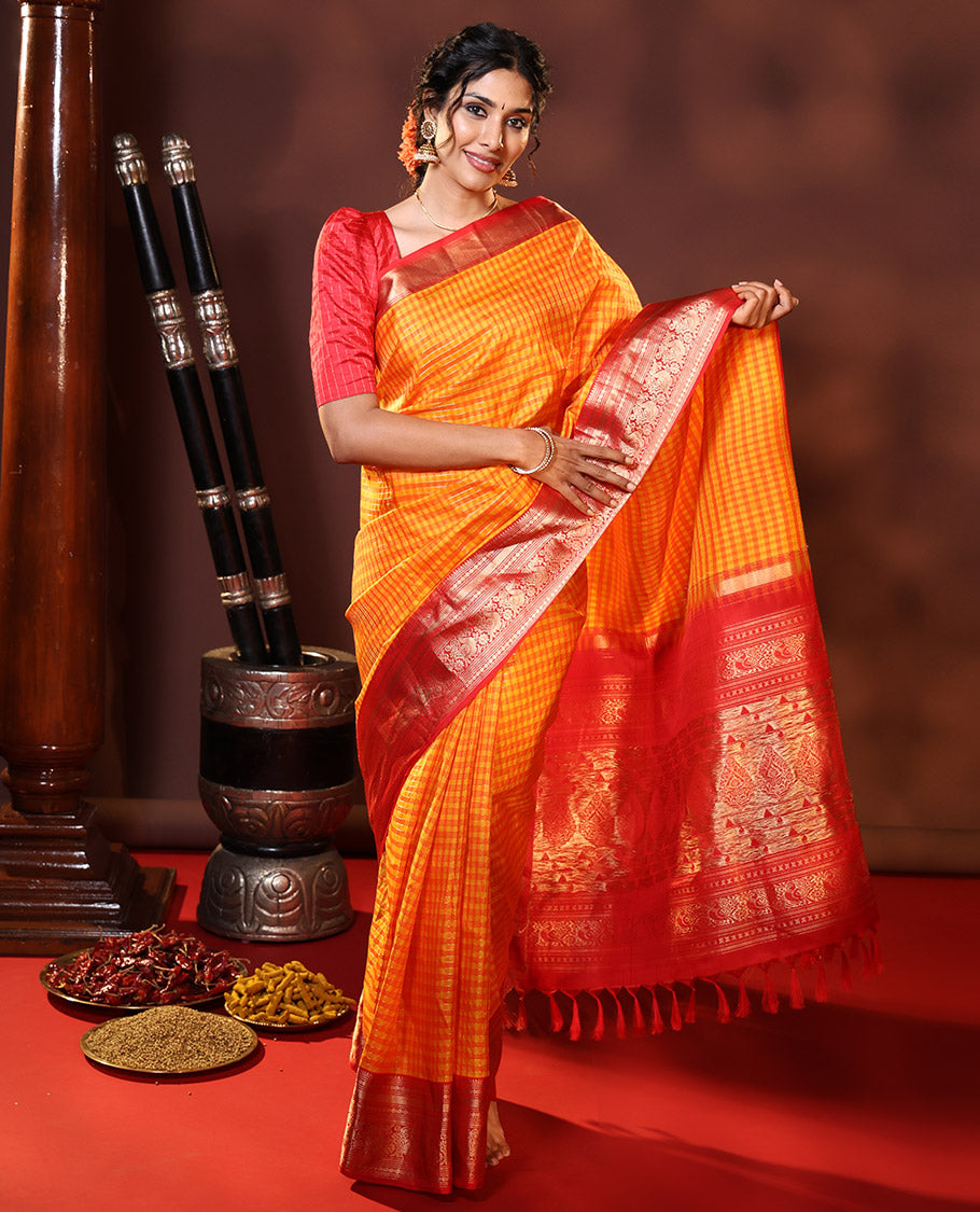Orange Vasundhara Silk Saree Decked Up with Checks All Over Its Body, Complemented by Contrast Border of Rekku, Neli, Rudraksham, Kathir, and Mayil Designs, a Grand Pallu of Intricate Designs, and Paired with a Contrast Blouse
